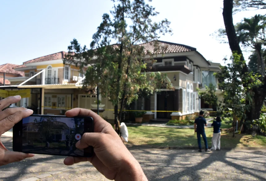 Jurnalis televisi merekam suasana rumah mewah yang dipasangi garis polisi usai penggeledahan di kawasan Sentul, Babakan Madang, Kabupaten Bogor, Jawa Barat, Kamis (9/7/2026).