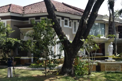 Jurnalis televisi merekam suasana rumah mewah yang dipasangi garis polisi usai penggeledahan di kawasan Sentul, Babakan Madang, Kabupaten Bogor, Jawa Barat, Kamis (9/7/2026).