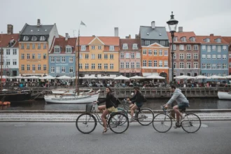 Wisatawan bersepeda di kawasan Nyhavn, Kopenhagen, Denmark