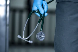 Seorang dokter membaewa stetoskop.