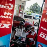 Petugas SPBU melayani pengisian bahan bakar minyak (BBM) kepada pengendara motor.