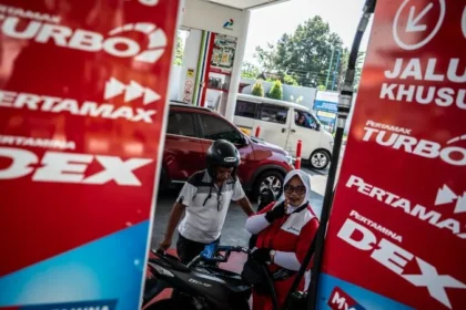 Petugas SPBU melayani pengisian bahan bakar minyak (BBM) kepada pengendara motor.