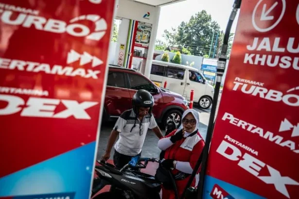 Petugas SPBU melayani pengisian bahan bakar minyak (BBM) kepada pengendara motor.