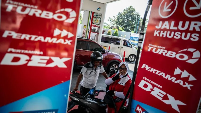 Petugas SPBU melayani pengisian bahan bakar minyak (BBM) kepada pengendara motor.