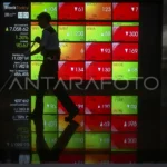 Pekerja membersihkan lantai di depan layar digital yang menampilkan pergerakan Indeks Harga Saham Gabungan (IHSG) di Bursa Efek Indonesia (BEI), Jakarta, Jumat (28/6/2024).