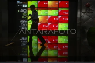 Pekerja membersihkan lantai di depan layar digital yang menampilkan pergerakan Indeks Harga Saham Gabungan (IHSG) di Bursa Efek Indonesia (BEI), Jakarta, Jumat (28/6/2024).