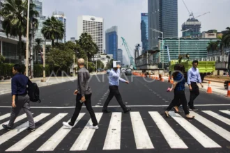 Pejalan kaki melintasi "pelican crossing" untuk menyeberang jalan di kawasan Bundaran Hotel Indonesia, Jakarta, Selasa (31/7/2018).
