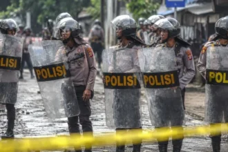 Ilustrasi polisi menjaga lokasi pasca bentrokan.