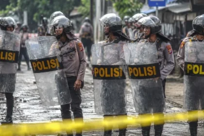 Ilustrasi polisi menjaga lokasi pasca bentrokan.
