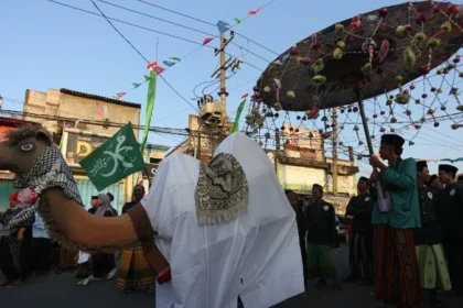 Peserta mengarak replika unta saat mengikuti pawai Maulid Nabi di Kampung Nelayan Nambangan-Cumpat, Surabaya.