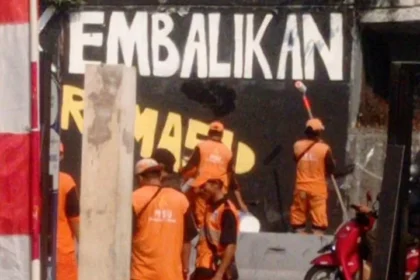 Petugas Dinas Kebersihan Jakarta Barat Menghapus Mural Mahasiswa Trisakti.