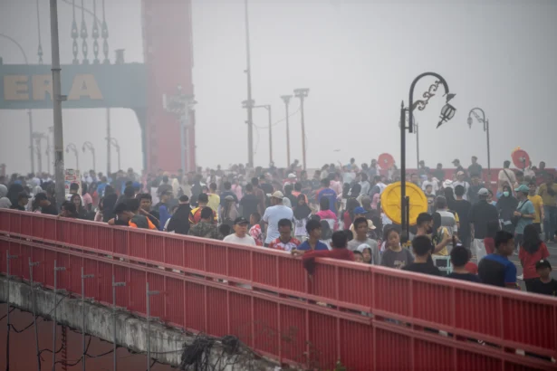 Sejumlah warga berolahraga di atas Jembatan Ampera yang tertutup kabut asap saat pelaksanaan hari bebas kendaraan bermotor (HBKB) di Kota Palembang, Sumatera Selatan, Minggu (23/8/2026).