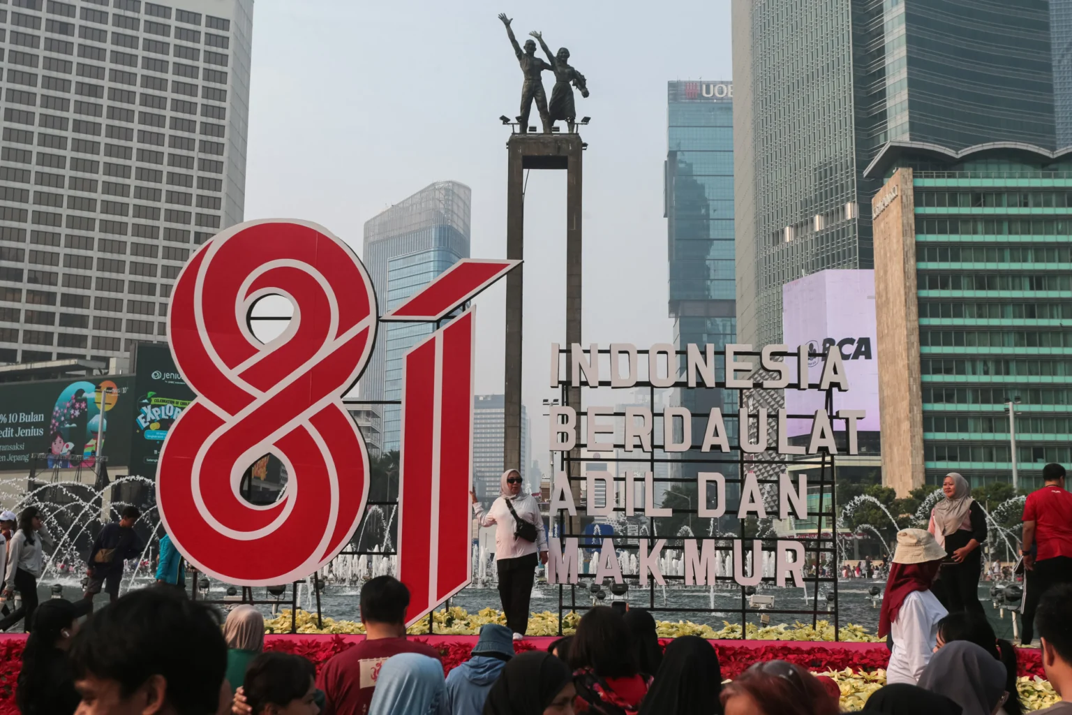 Warga berfoto di depan dekorasi perayaan Hari Kemerdekaan saat Hari Bebas Kendaraan Bermotor (HBKB) di kawasan Bundaran HI, Jakarta, Minggu (16/8/2026).