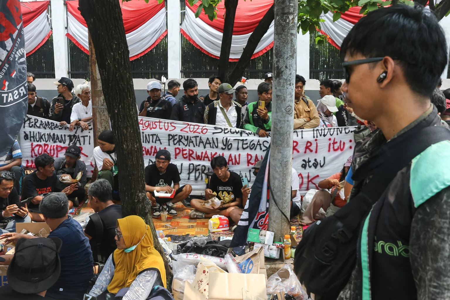 Massa Aliansi Masyarakat Pati Bersatu (AMPB) menyantap hidangan di depan Kompleks Parlemen, Jakarta, Rabu (26/8/2026).