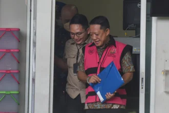 Tersangka yang merupakan mantan Jaksa Agung Muda Tindak Pidana Khusus (Jampidsus) Febrie Adriansyah (kanan) berjalan menuju mobil tahanan di Rutan Cabang KPK, Jakarta, Jumat (7/8/2026).