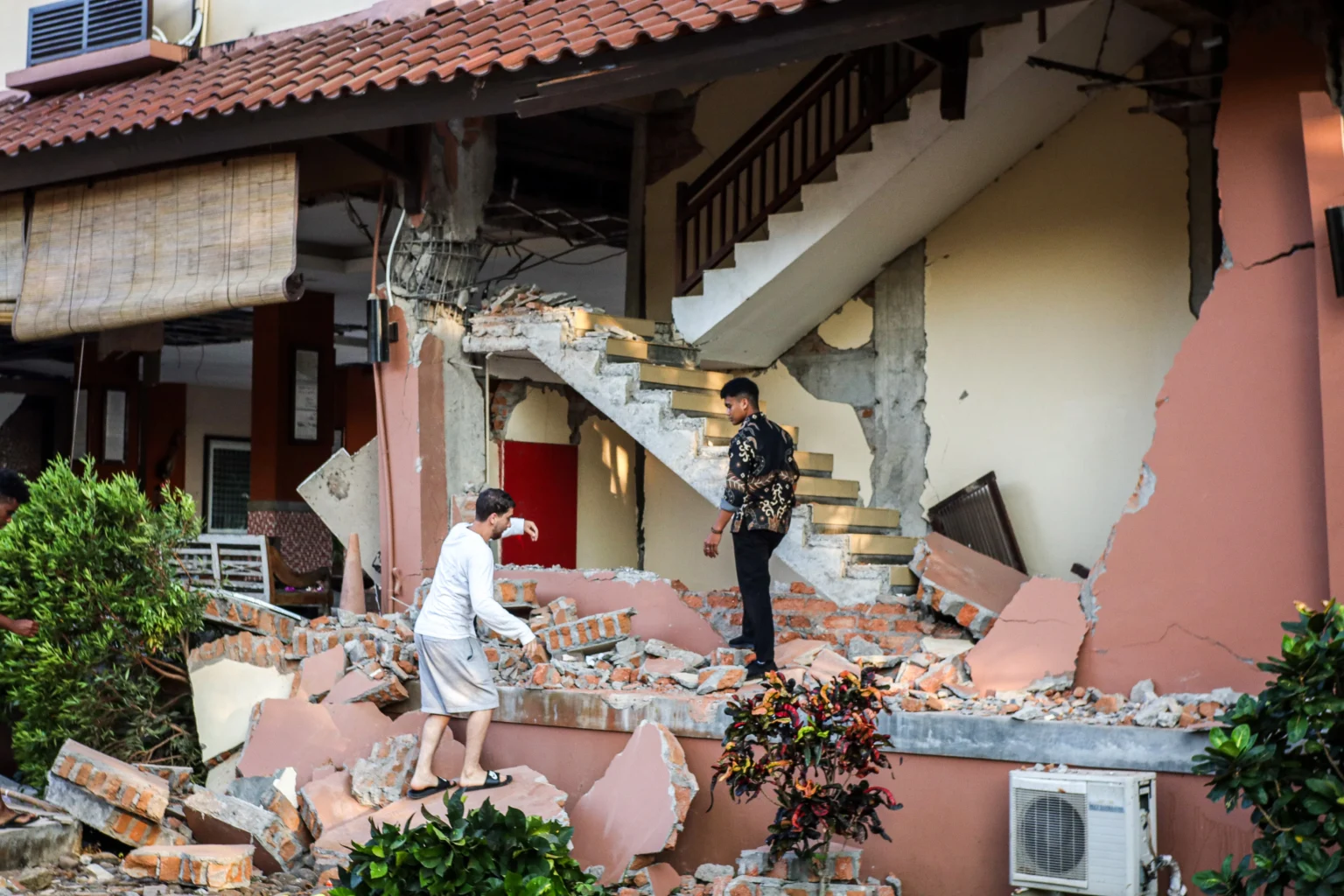 Pegawai dan wisatawan asing melihat gedung Hotel Jayakarta yang rusak akibat gempa di Labuan Bajo, Manggarai Barat, Nusa Tenggara Timur (NTT). (Sumber: Antara Foto/Gecio Viana/sth/nz)