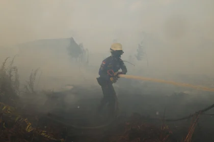 Personel Pemadam Kebakaran Pemerintah Kabupaten Kubu Raya menyemprotkan air ke lahan gambut yang terbakar di belakang Komplek Arwana Indah, Desa Arang Limbung, Kecamatan Sungai Raya, Kabupaten Kubu Raya, Kalimantan Barat