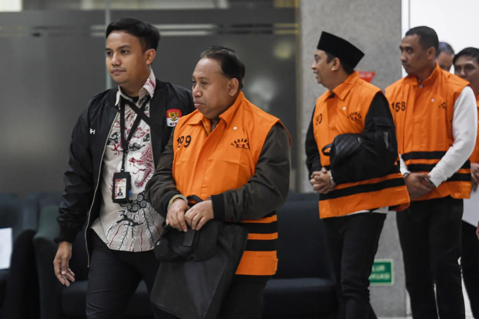 Rektor Universitas Jenderal Soedirman (Unsoed) Akhmad Sodiq (kedua kiri) berjalan menuju mobil tahanan seusai menjalani pemeriksaan di Gedung Merah Putih KPK, Jakarta, Sabtu (22/8/2026) dini hari.
