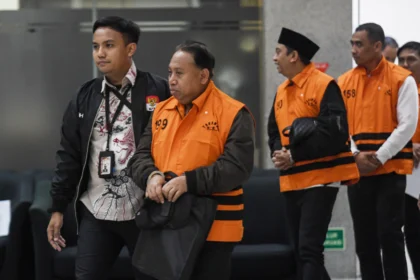 Rektor Universitas Jenderal Soedirman (Unsoed) Akhmad Sodiq (kedua kiri) berjalan menuju mobil tahanan seusai menjalani pemeriksaan di Gedung Merah Putih KPK, Jakarta, Sabtu (22/8/2026) dini hari.