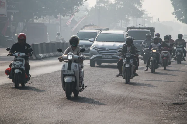Sejumlah pengendara melintas di Jalan Tjilik Riwut yang diselimuti asap di Palangka Raya, Kalimantan Tengah