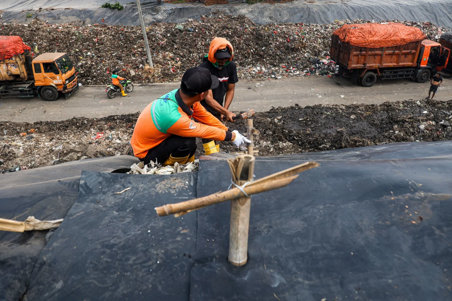 Petugas memasang patok pada geomembran sebagai media pelindung untuk menutup tumpukan sampah di Tempat Pengolahan Sampah Terpadu (TPST) Bantargebang, Kota Bekasi, Jawa Barat