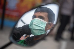 Pengendara memakai masker saat pembagian masker gratis di simpang empat RS Charitas Palembang, Sumatera Selatan, Senin (24/8/2026).