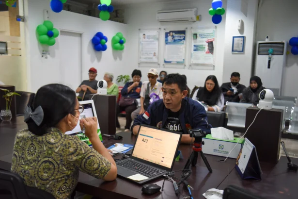 Petugas melayani warga peserta program BPJS Kesehatan di Kantor BPJS Kesehatan Cabang Jakarta Pusat, Jakarta