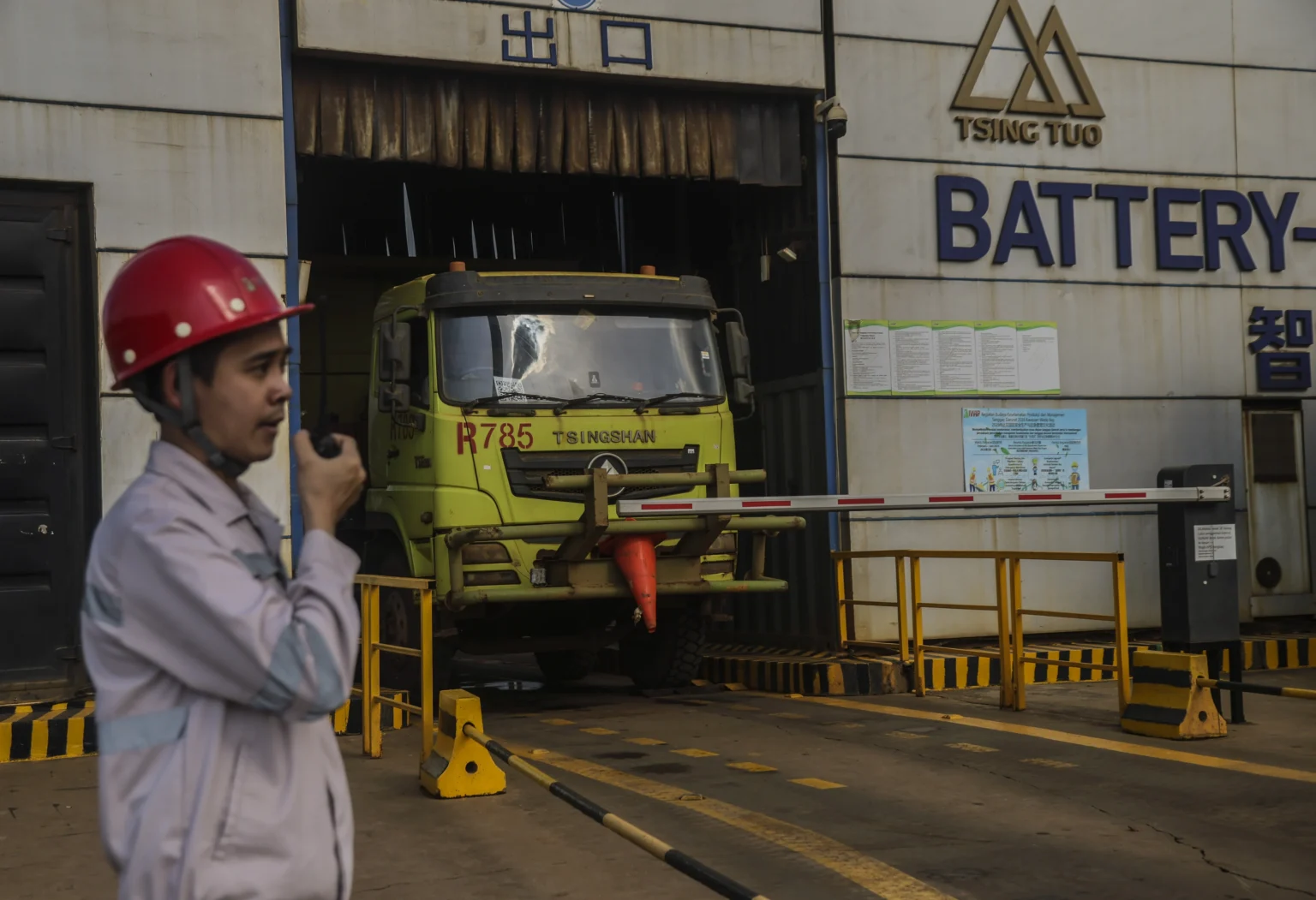 Seorang petugas berjaga saat sebuah armada truk jungkit (dump truck) listrik menukar baterai di Stasiun Pengisian dan Penukaran Baterai (battery swapping station) di kawasan Indonesia Weda Bay Industrial Park (IWIP), Kabupaten Halmahera Tengah