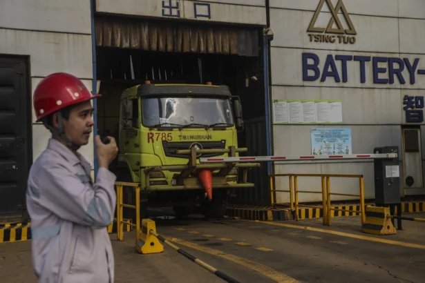 Seorang petugas berjaga saat sebuah armada truk jungkit (dump truck) listrik menukar baterai di Stasiun Pengisian dan Penukaran Baterai (battery swapping station) di kawasan Indonesia Weda Bay Industrial Park (IWIP), Kabupaten Halmahera Tengah