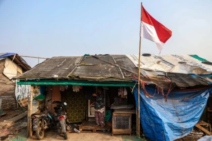 Seorang warga berdiri di depan rumahnya usai menjemur pakaian di Kampung Pemulung Cikiwul, Bantargebang, Kota Bekasi, Jawa Barat. (Sumber: Antara Foto/Darryl Ramadhan/tom)