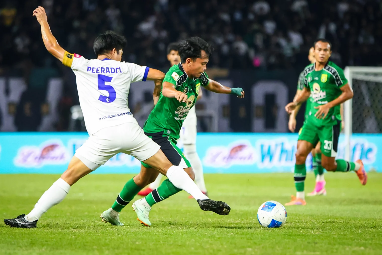 Pesepak bola Persebaya Surabaya Ricky Pratama (kedua kiri) berusaha melewati adangan pesepak bola Port FC Peeradol Chamrasamee (kiri) pada pertandingan Grup B Piala Presiden 2026 di Stadion Gelora Bung Tomo, Surabaya, Jawa Timur