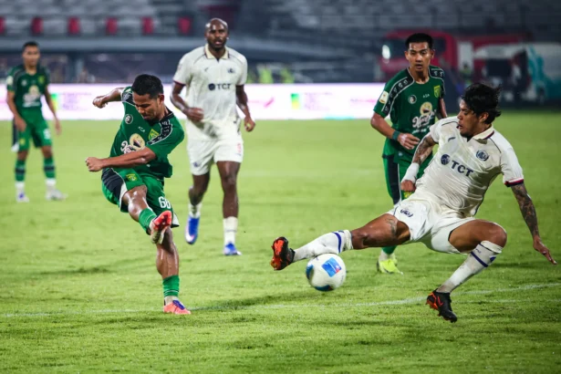 Pesepak bola Persebaya Surabaya Toni Firmansyah (kiri) menendang bola yang diadang pesepak bola Arema FC Roberto Pimenta (kanan) pada pertandingan semifinal Piala Presiden 2026 di Stadion Kapten I Wayan Dipta, Gianyar, Bali
