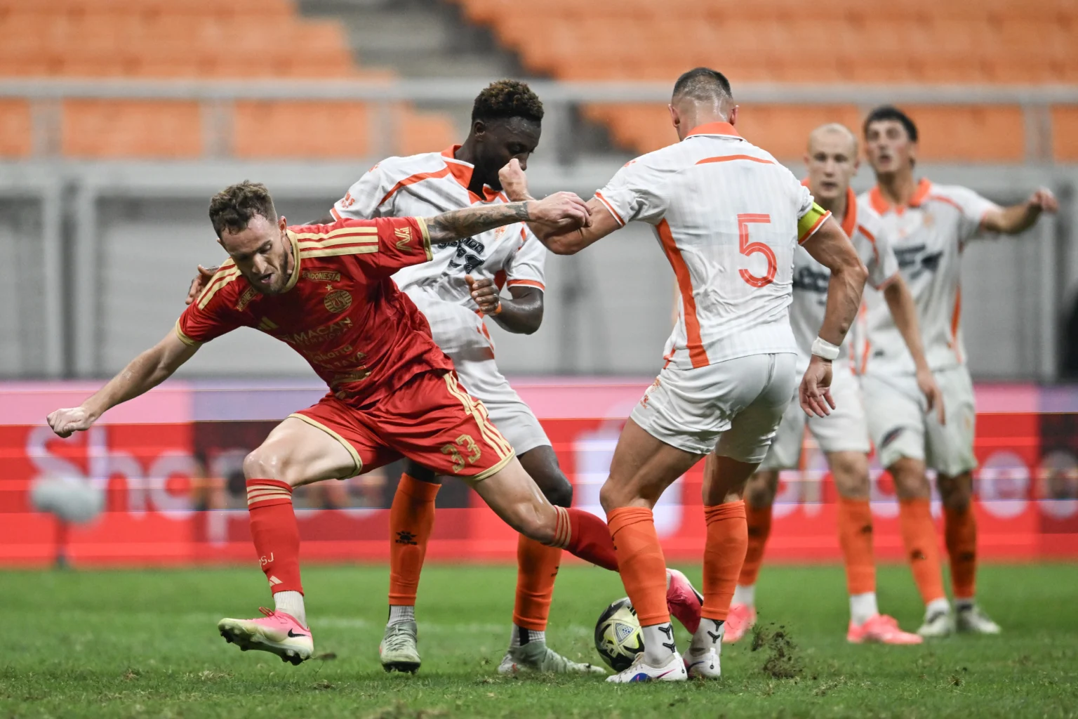 Pesepak bola Persija Jakarta Stjepan Loncar (kiri) melewati hadangan pesepak bola Brisbane Roar FC Thomas Aldred (ketiga kiri) dalam pertandingan persahabatan internasional di Jakarta International Stadium (JIS), Jakarta, Sabtu (29/8/2026).