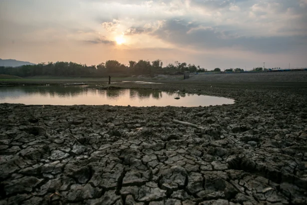 Warga melintas di dasar Waduk Tandon Krisak yang mengering akibat kemarau di Selogiri, Wonogiri, Jawa Tengah, Jumat (7/8/2026).