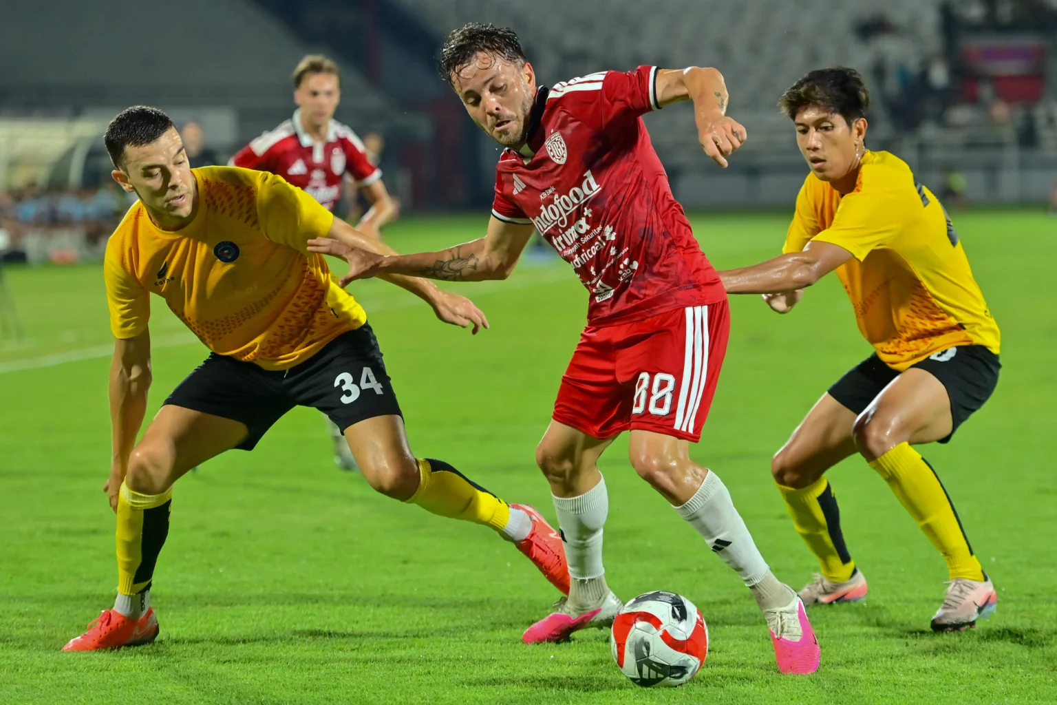 Pesepak bola Sabah FC Enrique Lopez (kiri) dan Mohd Fadzrul Danel (kanan) berusaha merebut bola dari Pesepak bola Bali United Queven Da Silva Inacio (tengah) saat pertandingan Dewata Challenge Series 2026 di Stadion Kapten I Wayan Dipta, Gianyar, Bali