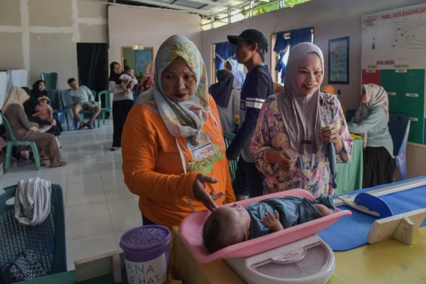 Petugas menimbang berat badan anak balita di Pos Pelayanan Terpadu (Posyandu) Palu, Sulawesi Tengah