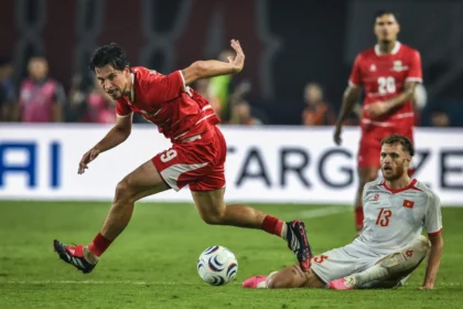 Pesepak bola Timnas Indonesia Thom Jan Marinus Haye (kiri) berebut bola dengan pesepak bola Timnas Vietnam Tai Loc Nguyen (kanan) pada pertandingan Grup A Piala AFF 2026 di Stadion Gelora Pakansari