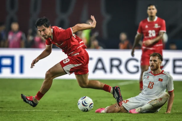 Pesepak bola Timnas Indonesia Thom Jan Marinus Haye (kiri) berebut bola dengan pesepak bola Timnas Vietnam Tai Loc Nguyen (kanan) pada pertandingan Grup A Piala AFF 2026 di Stadion Gelora Pakansari