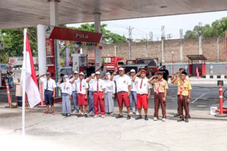 Petugas SPBU berbusana siswa sekolah mengikuti upacara pengibaran bendera Merah Putih di SPBU Plesungan, Kabupaten Karanganyar, Jawa Tengah, Senin (17/8/2026).