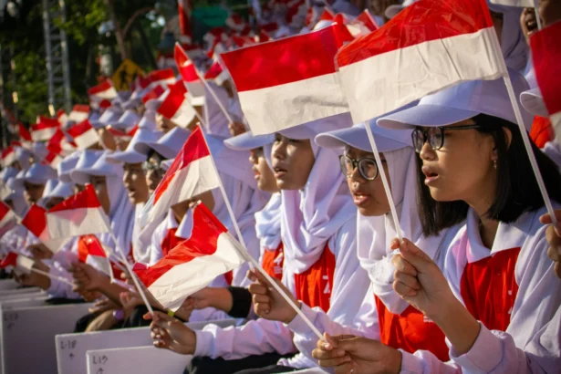 Anak-anak mengibarkan bendera Indonesia