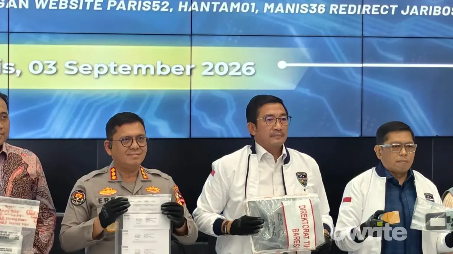 Dirtipidsiber Bareskrim Polri Brigjen Adex Yudiswan (jaket dan kemeja putih) memegang barang bukti kasus judol dengan keuntungan Rp260 miliar per bulan.