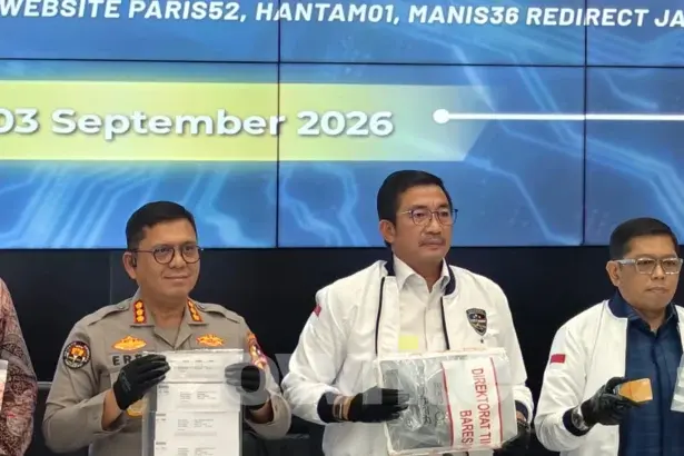 Dirtipidsiber Bareskrim Polri Brigjen Adex Yudiswan (jaket dan kemeja putih) memegang barang bukti kasus judol dengan keuntungan Rp260 miliar per bulan.