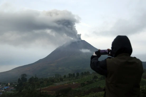 Wartawan memotret Gunung Sinabung saat menyemburkan abu vulkanik di Desa Kutarayat, Kecamatan Naman Teran, Kabupaten Karo, Sumatera Utara, Rabu (2/9/2026).