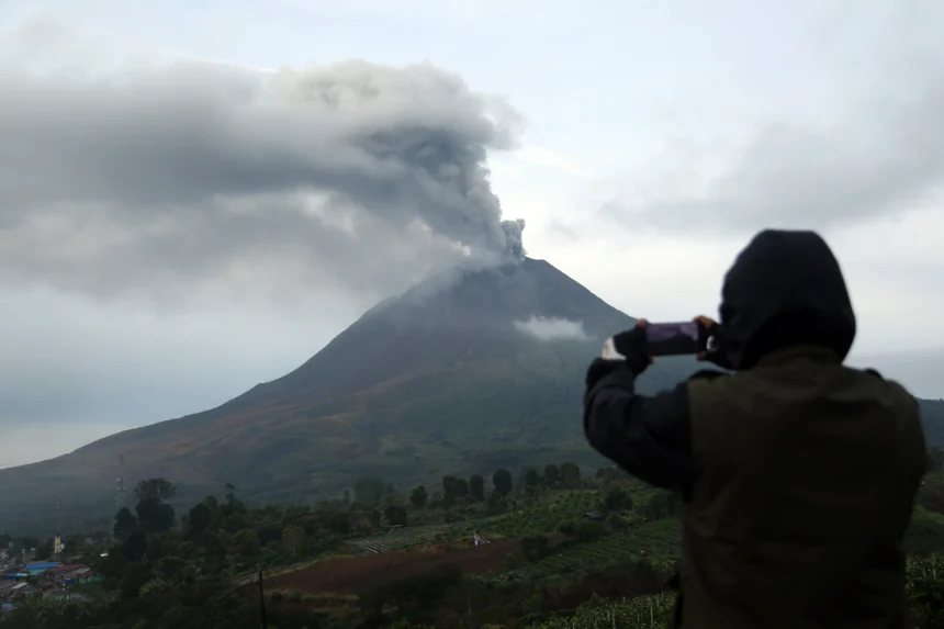 Wartawan memotret Gunung Sinabung saat menyemburkan abu vulkanik di Desa Kutarayat, Kecamatan Naman Teran, Kabupaten Karo, Sumatera Utara, Rabu (2/9/2026).