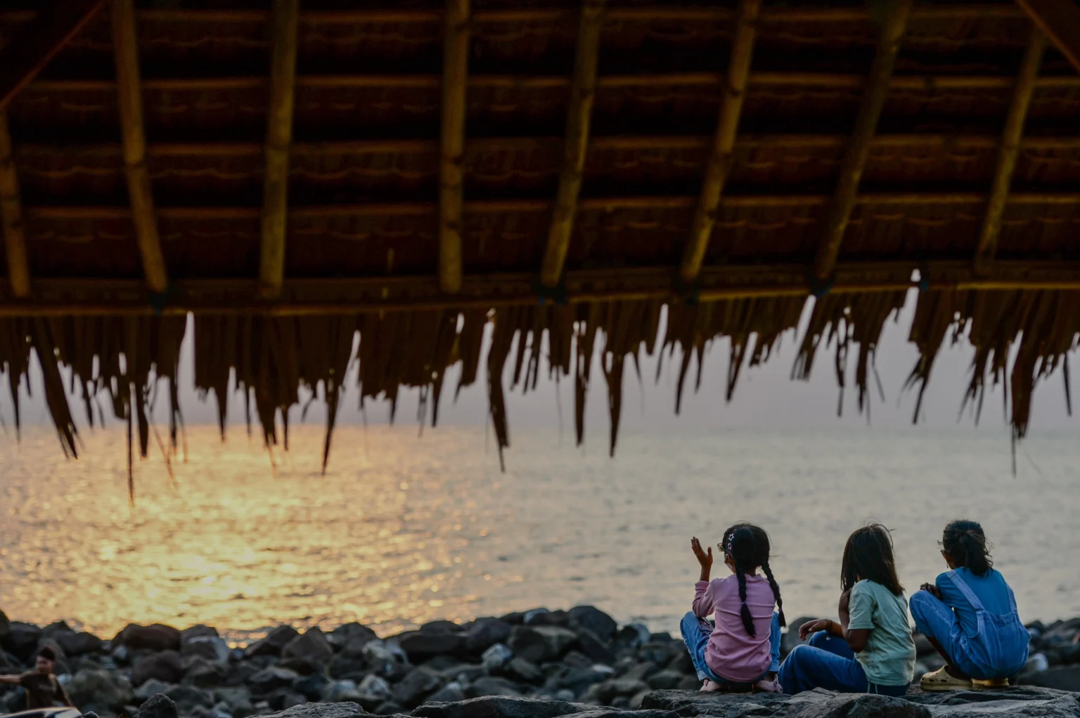 Sejumlah anak menikmati suasana matahari terbenam di Pantai Pasauran, Kabupaten Serang, Banten, Minggu (6/9/2026).