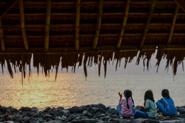 Sejumlah anak menikmati suasana matahari terbenam di Pantai Pasauran, Kabupaten Serang, Banten, Minggu (6/9/2026).