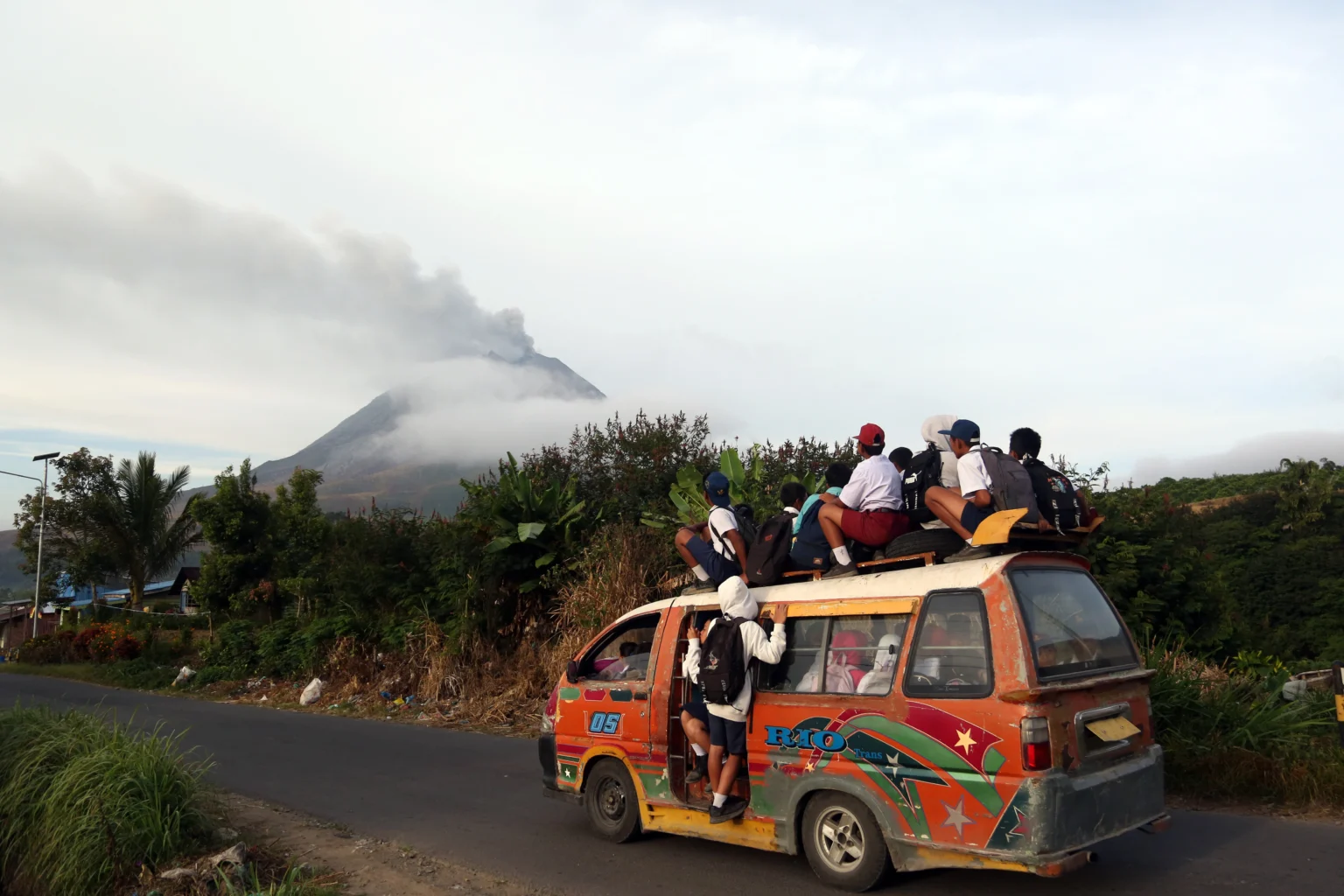 Siswa berangkat sekolah menaiki angkutan umum saat erupsi Gunung Sinabung di Desa Kutarayat, Kecamatan Naman Teran, Kabupaten Karo, Sumatera Utara, Selasa (1/9/2026).