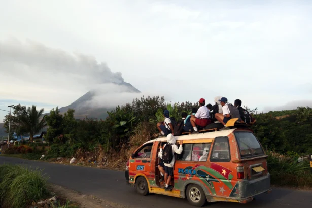 Siswa berangkat sekolah menaiki angkutan umum saat erupsi Gunung Sinabung di Desa Kutarayat, Kecamatan Naman Teran, Kabupaten Karo, Sumatera Utara, Selasa (1/9/2026).