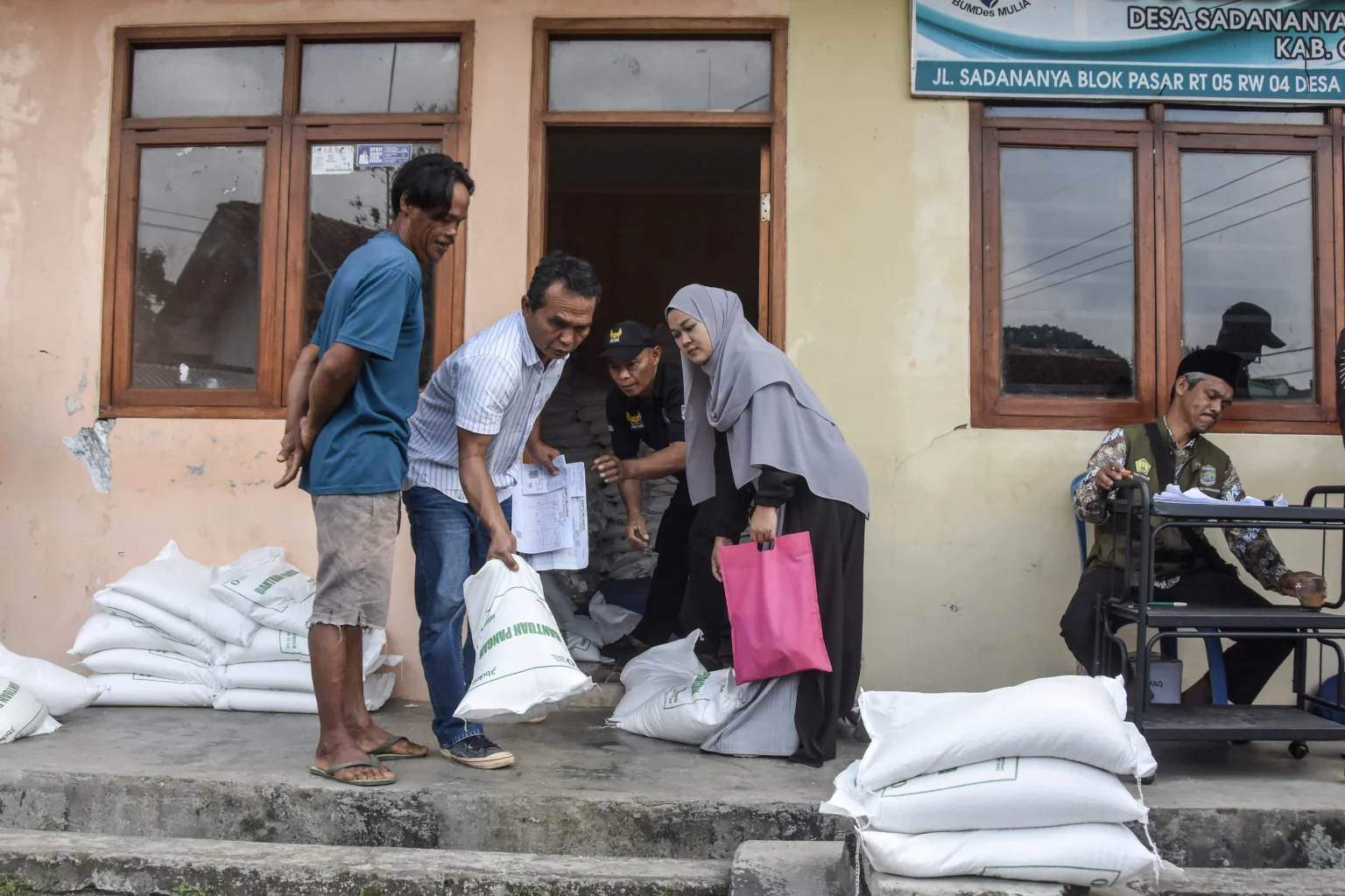 Warga dari Keluarga Penerima Manfaat (KPM) membawa beras bantuan setelah diperiksa kesehatannya di Kantor BUMDes Mulia, Desa Sadananya, Kecamatan Sadananya, Kabupaten Ciamis, Jawa Barat, Jumat (4/9/2026).