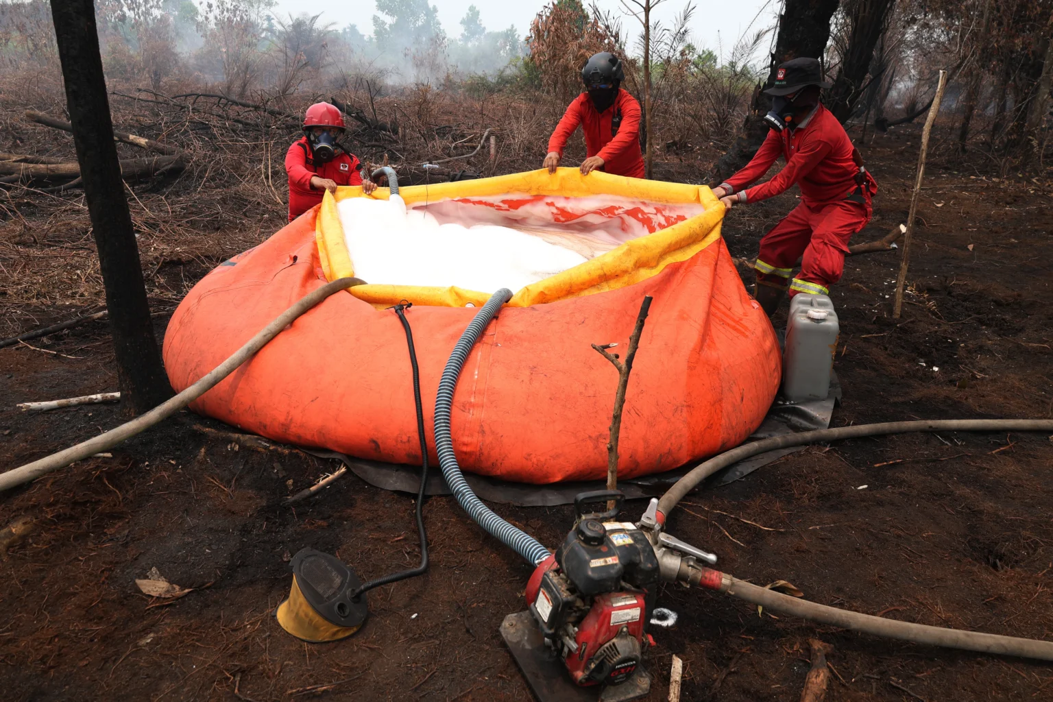 Tiga personel Daops Manggala Agni Kalimantan VIII/Pontianak menyiapkan water tank atau penampung air di lokasi pemadaman karhutla di Sekunder C, Rasau Jaya 3, Kabupaten Kubu Raya, Kalimantan Barat, Kamis (27/8/2026).